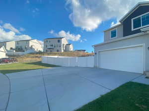 View of property exterior featuring a garage and a yard