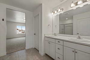 Bathroom with tile floors, a textured ceiling, double sink, and oversized vanity