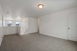 Unfurnished room featuring dark carpet