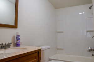 Full bathroom featuring toilet, vanity, and shower / washtub combination