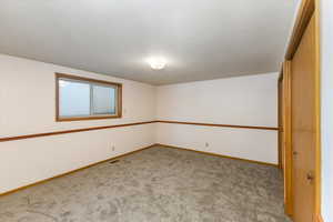 Unfurnished room featuring light colored carpet and a textured ceiling