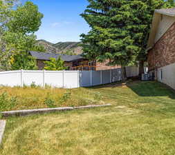 View of yard with a mountain view and central AC unit