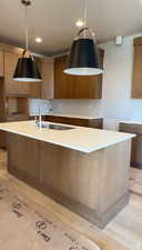 Kitchen with pendant lighting, a center island with sink, light hardwood / wood-style flooring, and sink