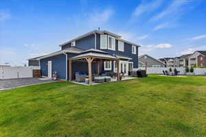 Back of property with a patio, a gazebo, an outdoor living space, and a yard