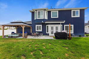 Back of house featuring outdoor lounge area, a patio, a yard, and a gazebo