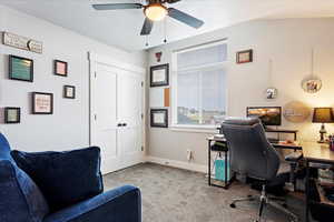 Carpeted office space with ceiling fan and a textured ceiling