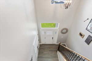 Entrance foyer with a towering ceiling, dark hardwood / wood-style floors, and a notable chandelier