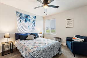 Carpeted bedroom featuring ceiling fan