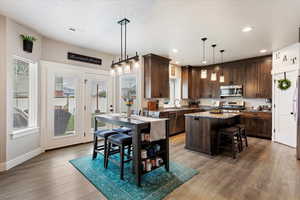 Kitchen featuring a center island, hanging light fixtures, hardwood / wood-style flooring, and stainless steel appliances