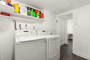 Washroom featuring washer and dryer, a textured ceiling, dark hardwood / wood-style floors, and hookup for a washing machine