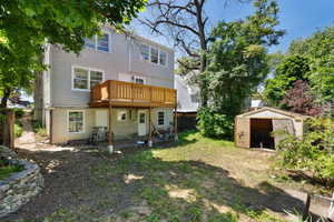 Back of house featuring a yard and a storage unit