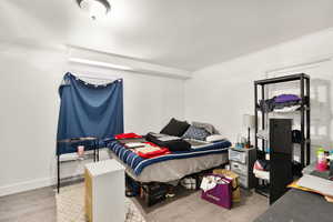 Bedroom with light hardwood / wood-style flooring and crown molding