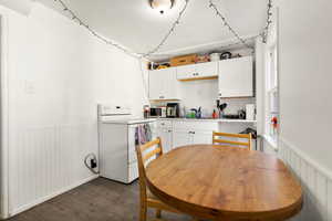 Kitchen with white cabinets, white range with electric cooktop, dark hardwood / wood-style flooring, and sink