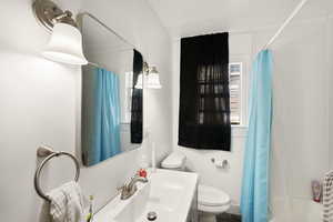 Full bathroom with vanity with extensive cabinet space, toilet, and shower / tub combo