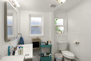 Bathroom featuring a textured ceiling, vanity, and toilet