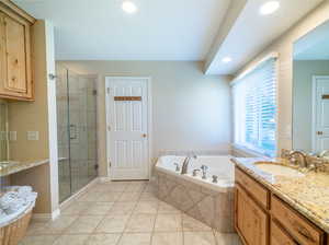 Bathroom featuring independent shower and bath, tile floors, and large vanity