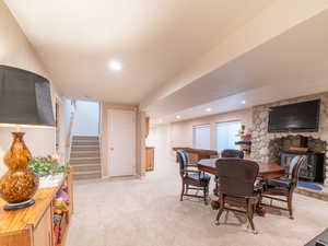 Dining space featuring light carpet and a wood burning stove