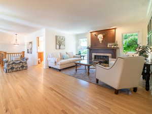 Living room featuring a healthy amount of sunlight, a tile fireplace, and light wood-type flooring.  Open floor concept