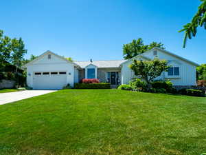 Ranch-style house featuring a 2 car  garage and a front yard