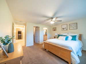 Carpeted bedroom featuring ceiling fan and ensuite bathroom