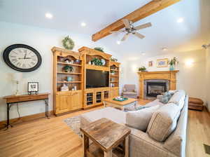 Living room with lofted ceiling with beams, light wood-type flooring, and ceiling fan