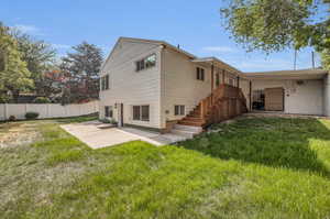 Rear view of property with a lawn and a patio area