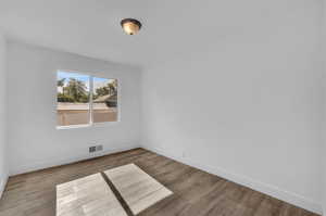 Spare room featuring wood-type flooring