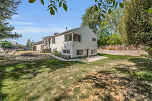 Rear view of house with a yard and a patio