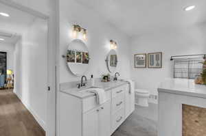 Bathroom with hardwood / wood-style floors, vanity, and toilet