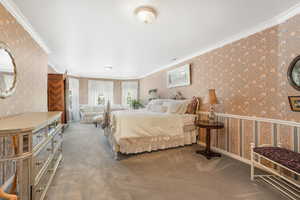 Owner Suite carpeted bedroom featuring crown molding