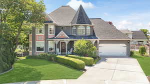 View of front of home with a garage and a front lawn