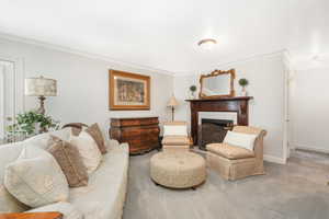 Family room featuring carpet flooring, a tiled fireplace and cherry mantle, and ornamental molding