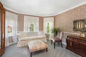 Owner Suite living room with ornamental molding and carpet flooring