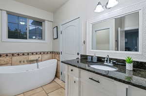 Bathroom featuring tile flooring, oversized vanity, and a bath