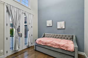 Bedroom with access to exterior and dark wood-type flooring