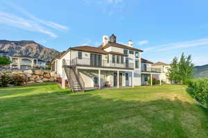 Back of property with a yard and a mountain view