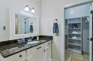 Bathroom with tile flooring and vanity with extensive cabinet space