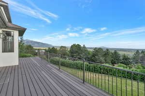 Wooden deck featuring a yard and a mountain view