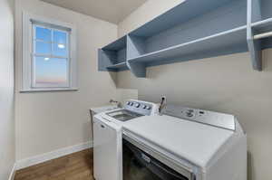 Laundry area with washing machine and dryer, sink, and hardwood / wood-style floors