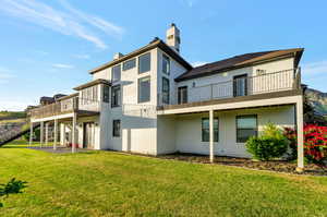 Rear view of house featuring a lawn