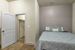 Bedroom with a walk in closet, a closet, and carpet