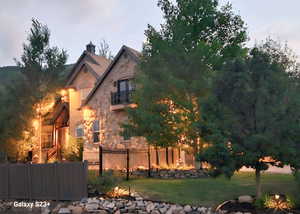 View of front of property with a balcony and a front yard