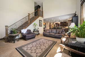 Living room featuring carpet flooring and a towering ceiling