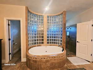 Bathroom featuring plus walk in shower and tile patterned flooring