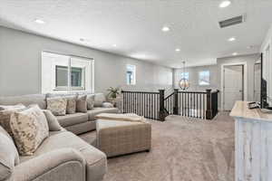 Carpeted living room featuring plenty of natural light and a textured ceiling