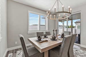 Dining space with a chandelier, hardwood / wood-style flooring, and a wealth of natural light