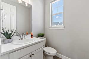 Bathroom featuring hardwood / wood-style flooring, a wealth of natural light, toilet, and vanity