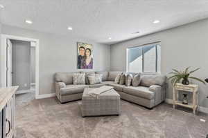 Living room featuring a textured ceiling and carpet flooring