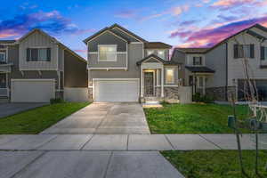 View of front facade with a garage and a yard