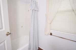 Bathroom with shower / bathtub combination with curtain